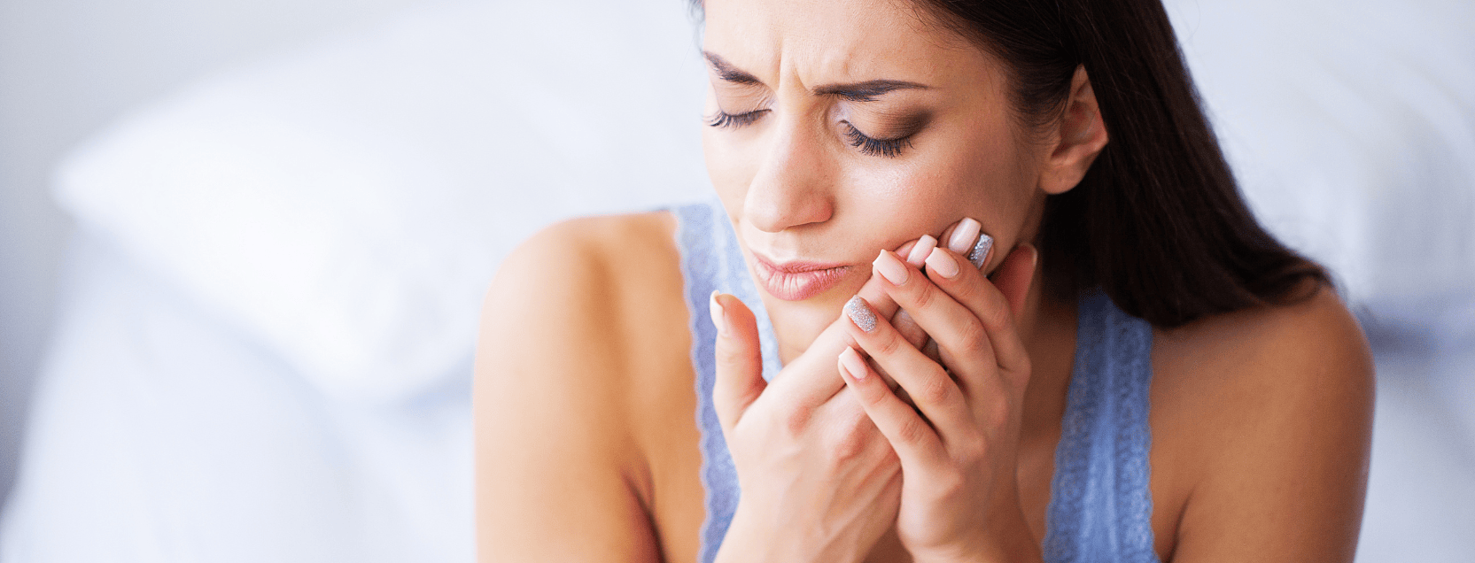 woman holding her mouth in pain